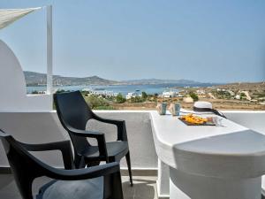 una mesa y sillas blancas con vistas al océano en Ocean View Paros en Parikia