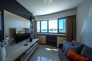 sala de estar con sofá y TV de pantalla plana en Flat com 2 quartos e vista MAR da PRAIA de PONTANEGRA-wifi 200 mb-garagem-FAMÍLIA-Crianças-piscina-PET friendly, en Natal