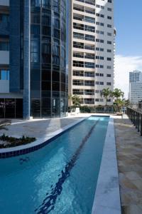 una piscina en un edificio con edificios altos en Flat com 2 quartos e vista MAR da PRAIA de PONTANEGRA-wifi 200 mb-garagem-FAMÍLIA-Crianças-piscina-PET friendly, en Natal