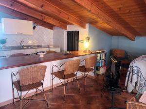eine Küche mit Stühlen und einer Theke in einem Zimmer in der Unterkunft Il Vecchio Lentisco in Alghero