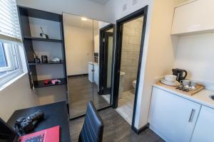 バーミンガムにあるCosy Studio close to University of Birminghamのキッチン、デスク、シンクが備わる客室です。 +2枚の写真