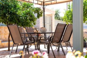 a table and chairs under an umbrella on a patio at Sea and Airport in Artemida