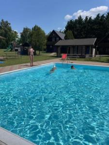 two people swimming in a large swimming pool at Kemp Josef Dubňany in Dubňany