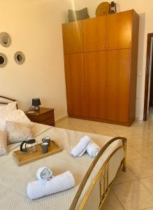 1 dormitorio con 1 cama con toallas y armario de madera en Casa Amalia, en Paradeísion