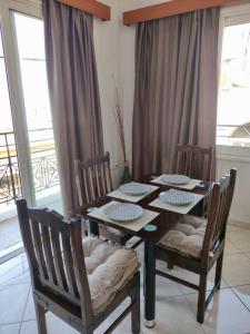 una mesa de comedor con 2 sillas y una mesa con platos. en Casa Amalia, en Paradeísion