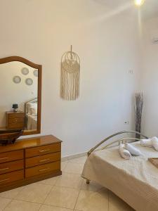 a bedroom with a bed and a dresser and a mirror at Casa Amalia in Paradeísion