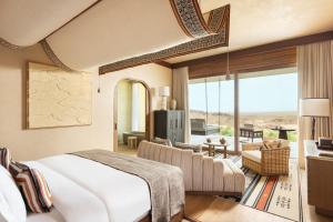 1 dormitorio con 1 cama y sala de estar en Six Senses Southern Dunes, The Red Sea 