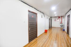 a hallway with a large door and a wooden floor at FabExpress Umbrella in Patna