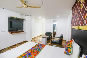 um quarto com uma cama e uma televisão em FabExpress Umbrella em Patna