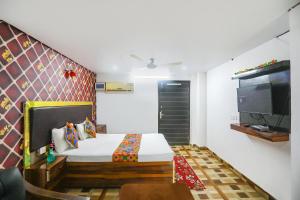 a bedroom with a bed and a flat screen tv at FabExpress Umbrella in Patna