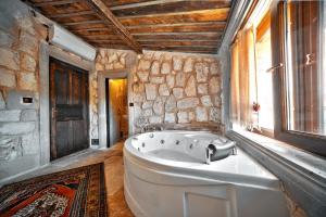 a large bath tub in a room with a stone wall at Aysel Inn House in Avcılar
