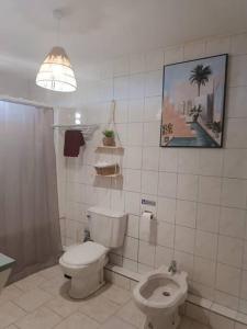 a white bathroom with a toilet and a sink at Bas de villa (T4) proche de la plage in Bouillante