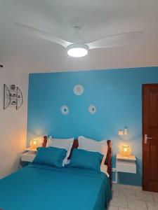 a blue bedroom with a bed with a blue headboard at Bas de villa (T4) proche de la plage in Bouillante