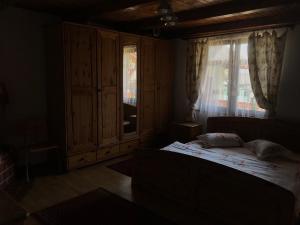 Habitación oscura con cama y ventana en Căsuța din munți en Sadova