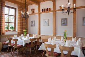 un comedor con mesas y sillas blancas en Hotel am Regenbogen en Cham