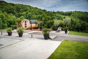 a person sitting on a bench in front of a tiny house at Resort TimAJA - pool, massage pool, sauna in Trebnje