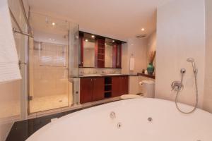 ein großes Bad mit einer Badewanne und einer Dusche in der Unterkunft 31 Cormoran Umhlanga Rocks in Durban
