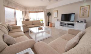 ein Wohnzimmer mit 2 Sofas und einem TV in der Unterkunft 31 Cormoran Umhlanga Rocks in Durban