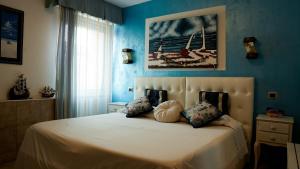 サン・ピエトロ・イン・カリアーノにあるFlorivana Boutique Hotel Ristoranteの青い壁のベッドルーム1室(大型ベッド1台付)