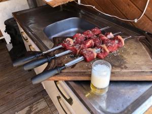 een snijplank met vlees en een glas bier bij Vale de cambara III in Cambará