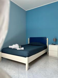 een blauwe slaapkamer met een bed met een blauwe muur bij Claire Rose B&B in Matera