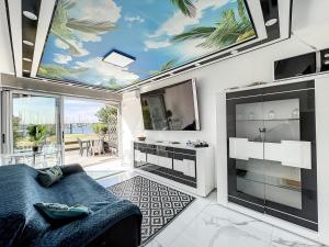 uma sala de estar com um sofá azul e uma televisão em 24 Appart Tropic Deluxe em Cap d'Agde