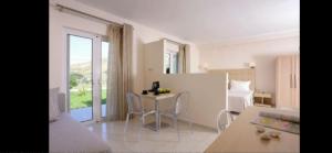 a kitchen and living room with a table and chairs at Ammos Suites in Plati