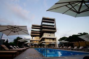 a hotel with a swimming pool and a building with umbrellas at Hotel Nobilis Hall in K'obulet'i
