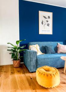a living room with a blue couch and a wooden floor at theSunset Club - STUDIO Küche - Balkon - Parken in Memmingen