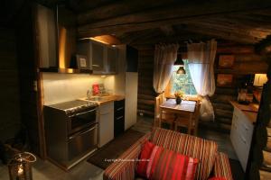 una cucina in una baita di tronchi con tavolo e finestra di Holiday Home Aurora Cabin a Luosto