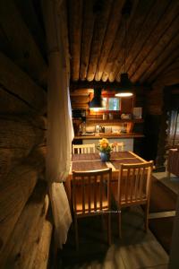 uma sala de jantar com uma mesa de madeira e 2 cadeiras em Holiday Home Aurora Cabin em Luosto