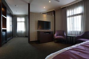 um quarto de hotel com uma cama e uma televisão de ecrã plano em Hotel Formosa em Caotun