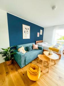 a living room with a green couch and a table at Sunset Club - STUDIO Küche - Balkon - Parken in Memmingen