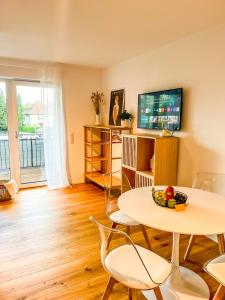 a living room with a table and chairs and a tv at theSunset Club - STUDIO Küche - Balkon - Parken in Memmingen