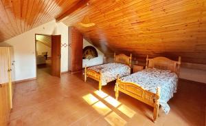 um quarto com 2 camas e um tecto de madeira em Quinta Do Pereiro em Tábua