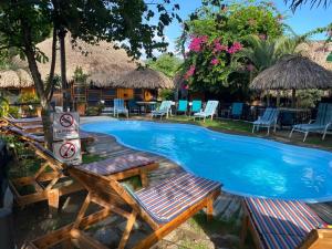 um resort com uma piscina com cadeiras e mesas em Bikini Hotel & Pool em Palomino