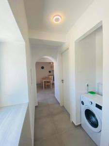 a laundry room with a washing machine and a hallway at Olive tree cottage in Elia Laconias