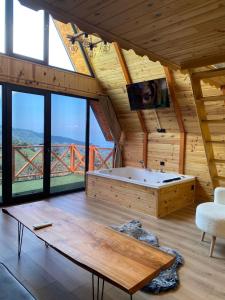 ein Bad mit einer Badewanne in einem Zimmer mit Aussicht in der Unterkunft Green Luxury Bungalovs in Pazar