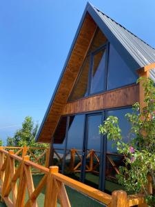 a house with glass windows and a wooden fence at Green Luxury Bungalovs in Pazar