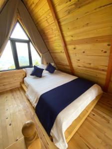 a bedroom with a bed in a wooden cabin at Green Luxury Bungalovs in Pazar