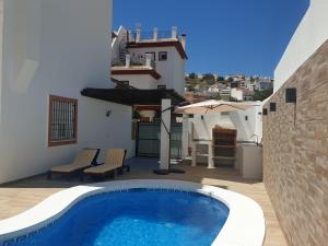 a house with a swimming pool on a patio at El Burré in Tolox