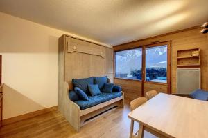 a living room with a blue couch and a large window at Rare pearl with incredible views in Les Houches