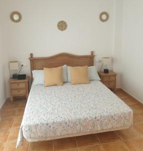 a bedroom with a bed with two night stands and two lamps at El Burré in Tolox