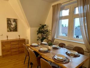 a dining room table with chairs and a large window at Stilvolles Apartment im Zentrum in Zittau +20 photos