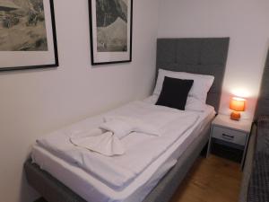 a bedroom with a white bed with two pictures on the wall at Wellness Rezort Tatranská Štrba in Tatranska Strba