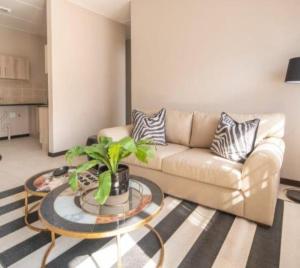 una sala de estar con un sofá y una mesa en Golden Oaks Complex, en Boksburg