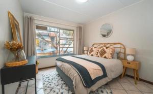 Un dormitorio con una cama grande y una ventana. en Golden Oaks Complex, en Boksburg