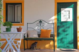 a cat sitting on a bench next to a table at Casinha Robusto in Salvaterra de Magos