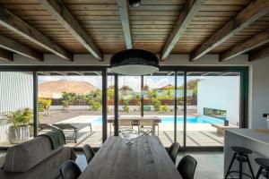 ein Esszimmer und ein Wohnzimmer mit einem Holztisch in der Unterkunft Villa Borea - AlisiaFuerteventura in Villaverde