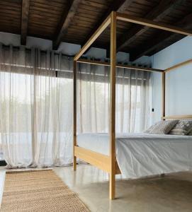 ein Schlafzimmer mit einem Himmelbett vor einem Fenster in der Unterkunft Villa Borea - AlisiaFuerteventura in Villaverde + 38 Fotos